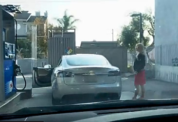 Elektrikli Tesla aracına benzin doldurmaya çalışan kadın.
